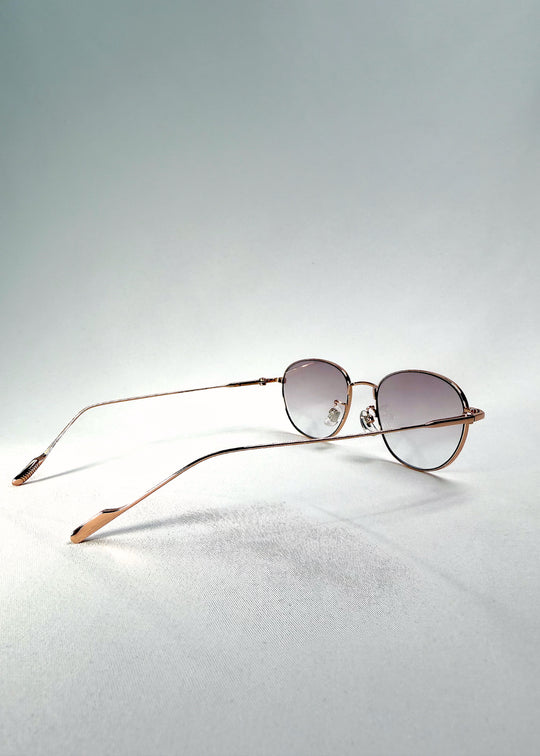 Back-angle view of Solen Softint sunglasses in Dawnveil showing gold temples and light lilac-grey lenses.