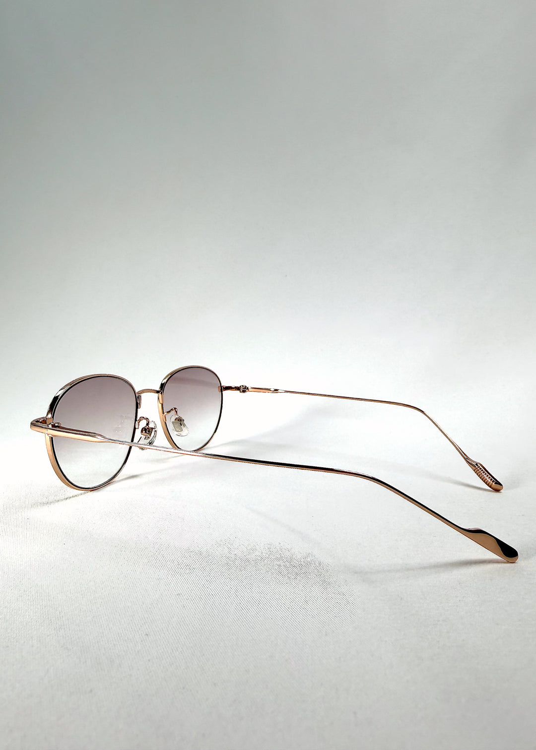 Front-angle view of Solen Softint sunglasses in Dawnveil featuring golden steel frame and soft lilac-grey tint.