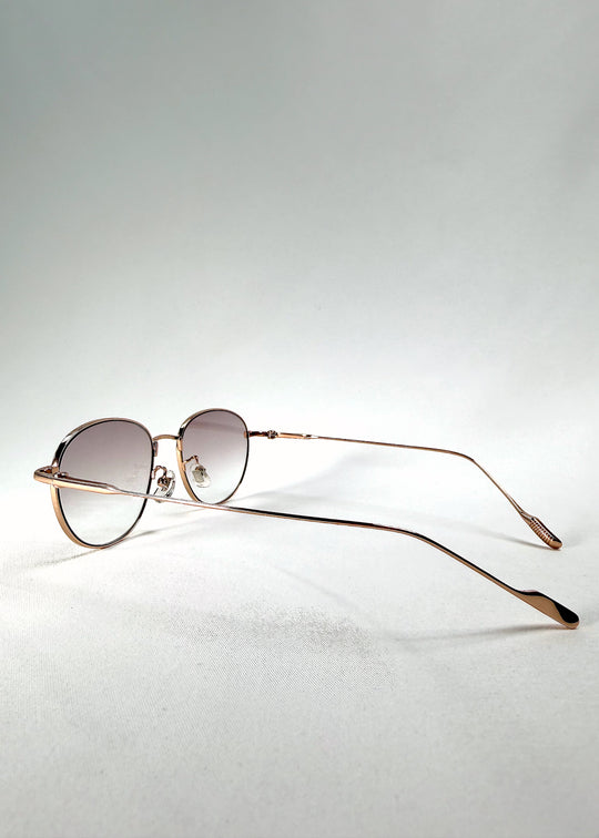Front-angle view of Solen Softint sunglasses in Dawnveil featuring golden steel frame and soft lilac-grey tint.