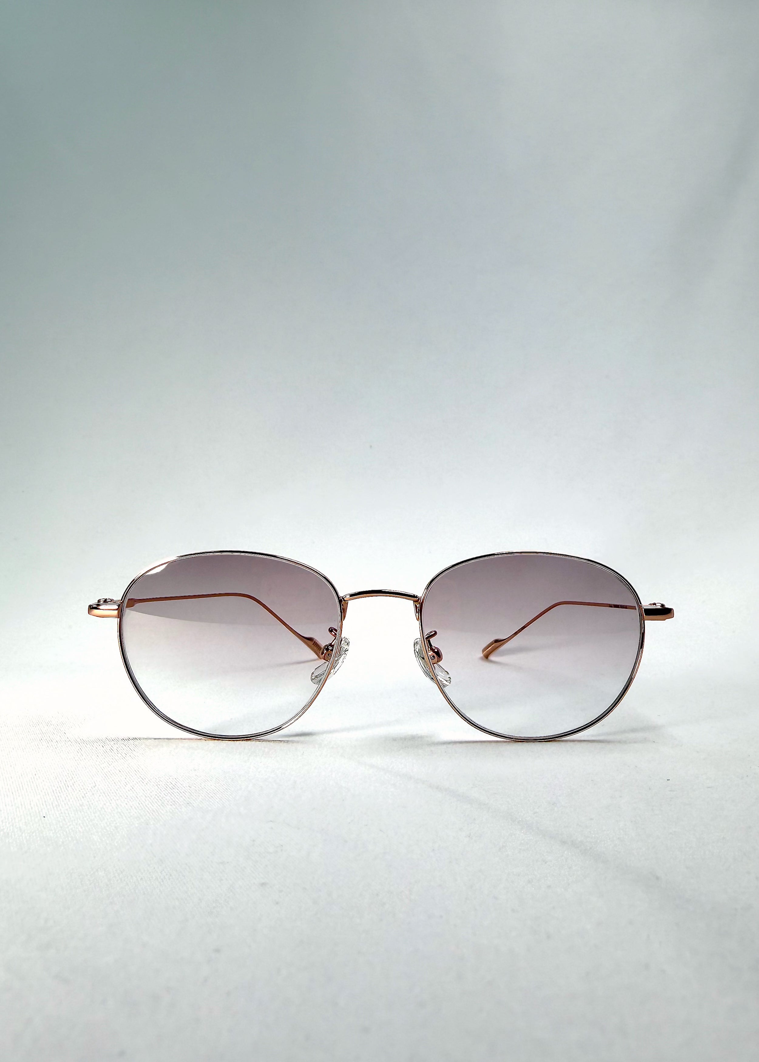 Front view of Solen Softint sunglasses in Dawnveil with round gold frame and lilac-grey Softint lenses.