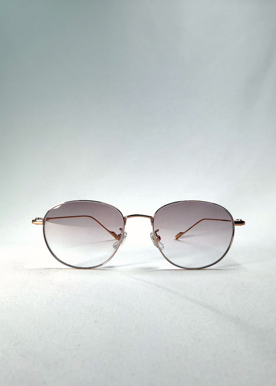 Front view of Solen Softint sunglasses in Dawnveil with round gold frame and lilac-grey Softint lenses.
