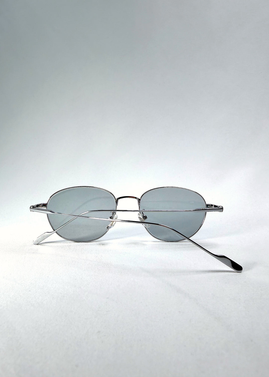 Folded-angle view of Solen Softint sunglasses in Moonveil highlighting minimalist frame construction.