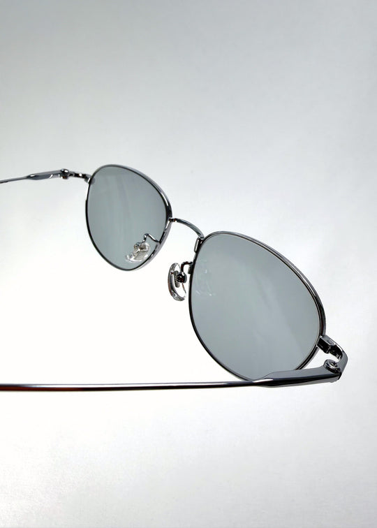 Close-up of the hinge on Solen Softint sunglasses in Moonveil, showing the silver frame and titanium temple connection. 