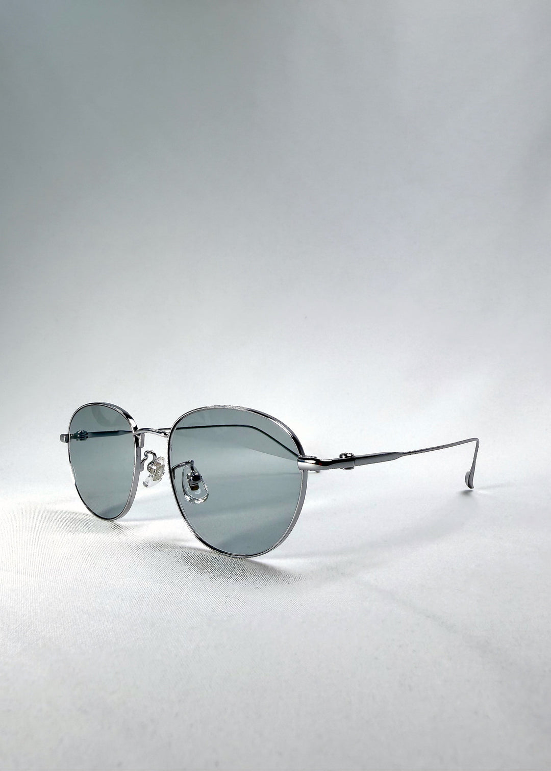 Side-temple view of Solen Softint sunglasses in Moonveil, showing the ultra-slim titanium temples and adjustable nose pads. 
