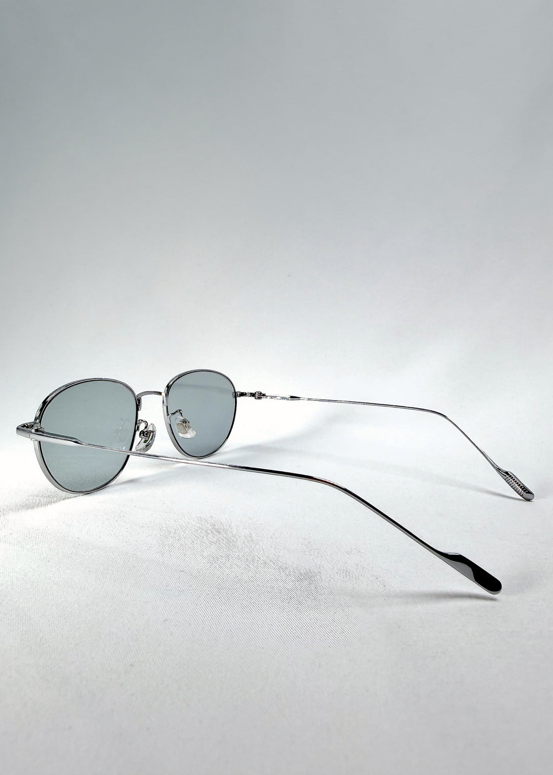 Three-quarter view of Solen Softint sunglasses in Moonveil capturing reflective silver tone and pale grey tint.