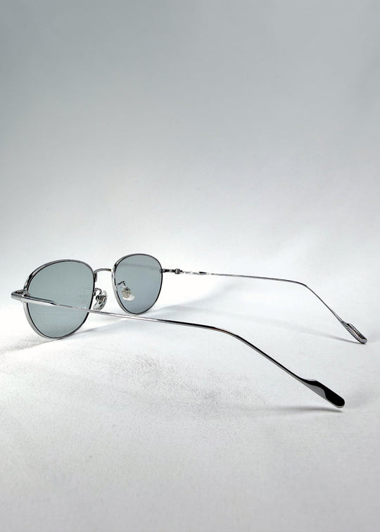 Three-quarter view of Solen Softint sunglasses in Moonveil, showing the reflective silver frame and pale blue-grey lenses. 