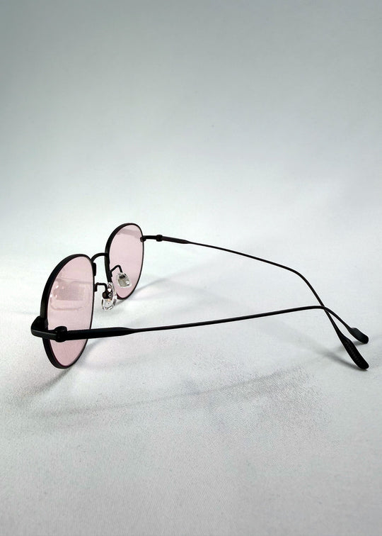 Back-angle view of Solen Softint sunglasses in Nightveil, showing the matte black frame and rose-tinted lenses. 