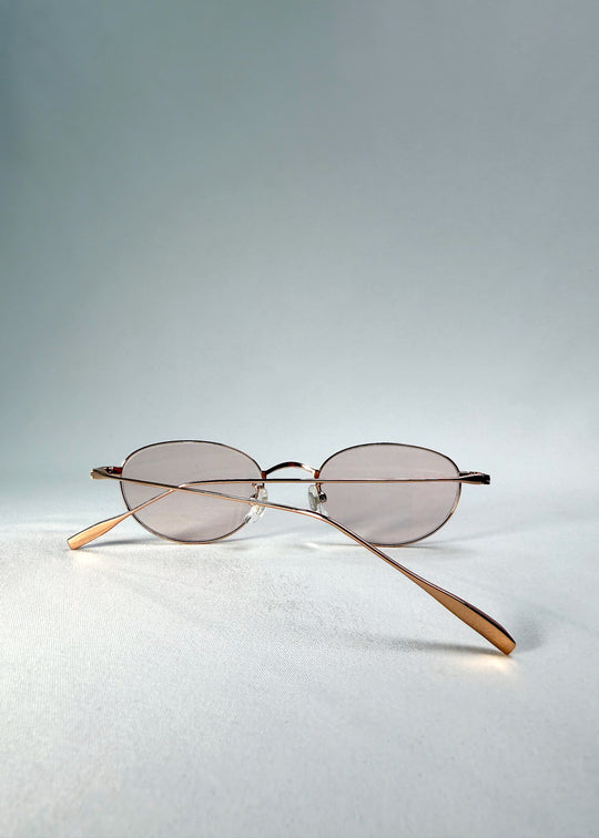 Folded front view of Vanta Arc Softint sunglasses in Duskgold displaying gold frame and rose-beige Softint lenses.