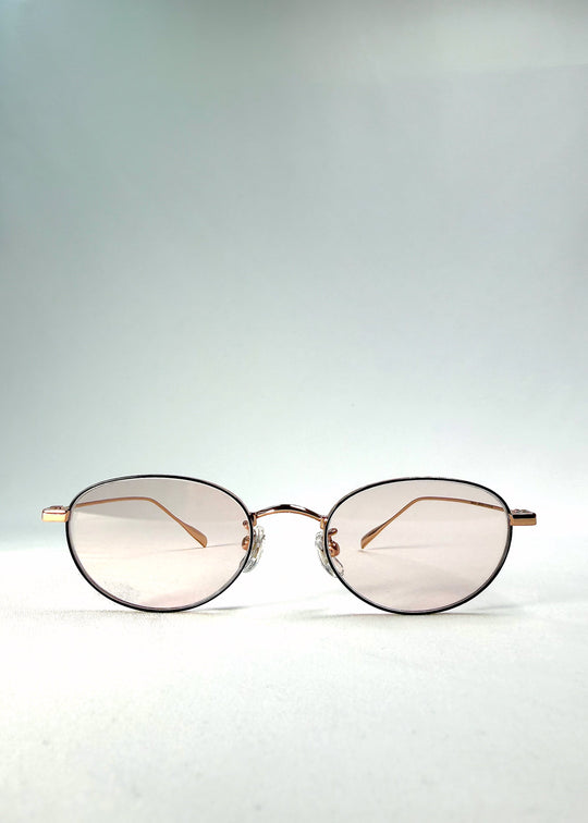 Front view of Vanta Arc Softint sunglasses in Champagne Gold showing the gold oval frame and pale rose-beige lenses. 