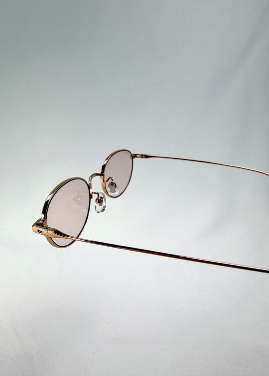 Close-up of Vanta Arc Softint sunglasses in Champagne Gold highlighting the hinge detail and rose-beige lens tint. 