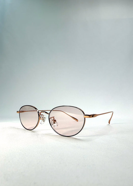 Left front-angle view of Vanta Arc Softint sunglasses in Champagne Gold showing the warm metallic finish and rose-beige lenses. 