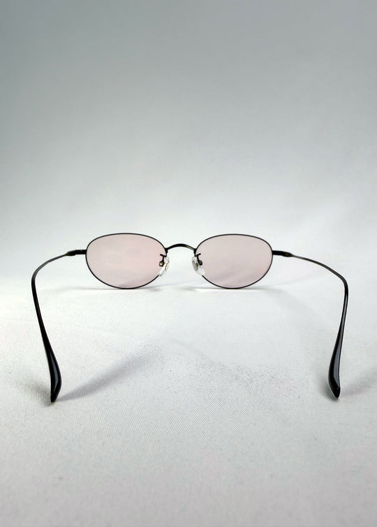 Back view of Vanta Arc Softint sunglasses in Blush Noir showing the lightweight black titanium temples and oval frame. 