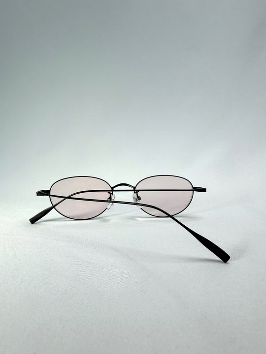 Folded view of Vanta Arc Softint sunglasses in Obsidian Black showing matte black frame and rose Softint lenses.