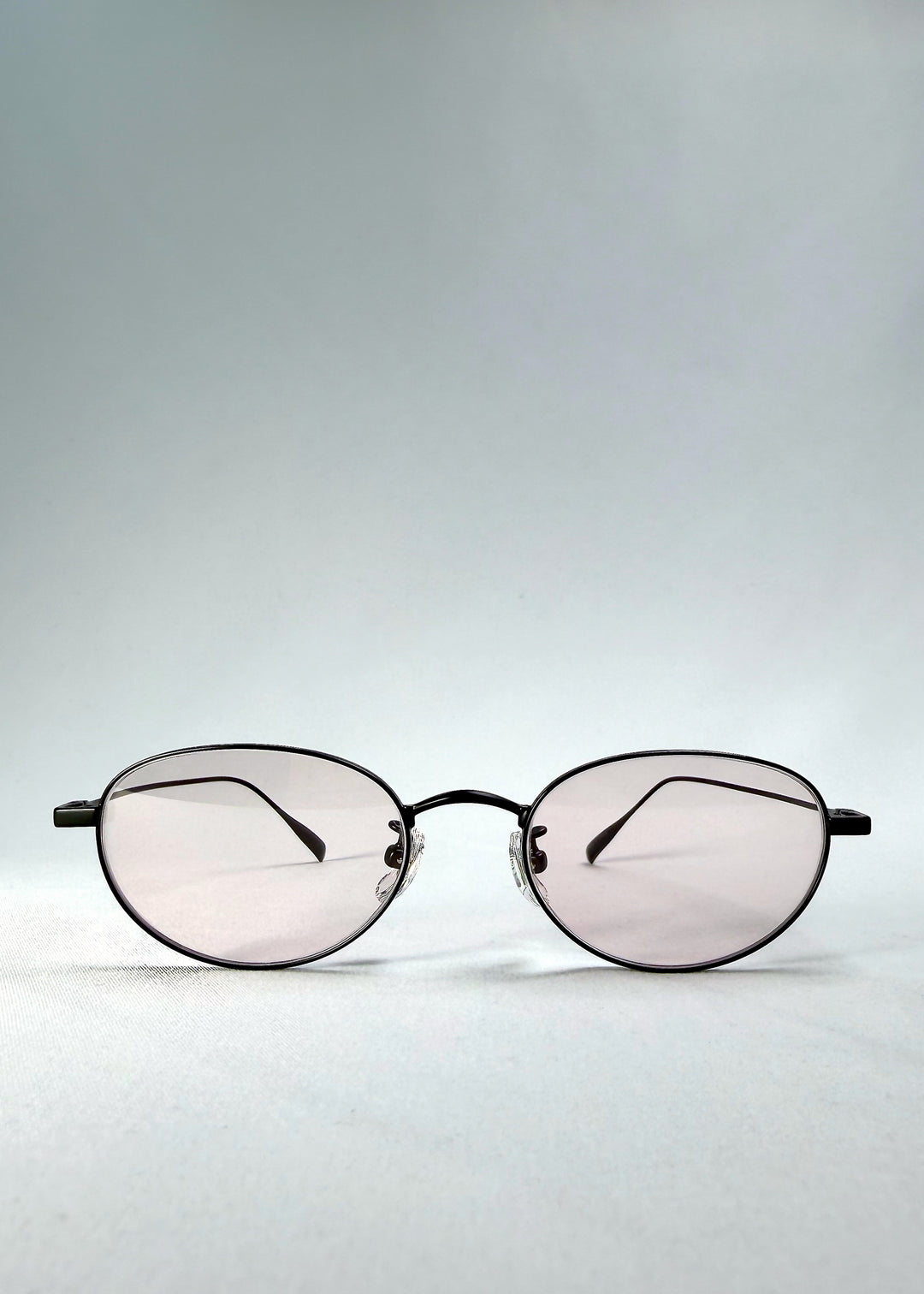 Front view of Vanta Arc Softint sunglasses in Obsidian Black showing oval silhouette and rose Softint lenses with UV400 protection.