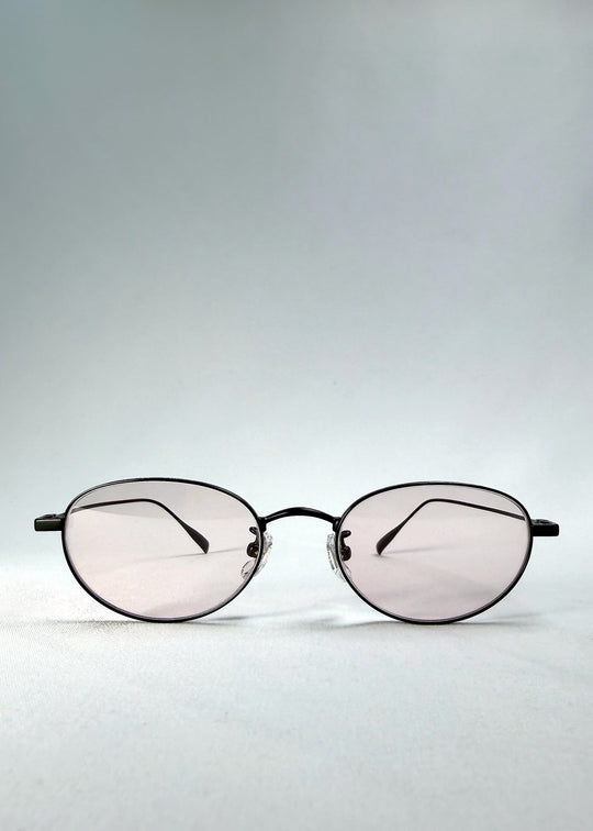 Front view of Vanta Arc Softint sunglasses in Blush Noir showing the black oval frame and pale blush lenses. 