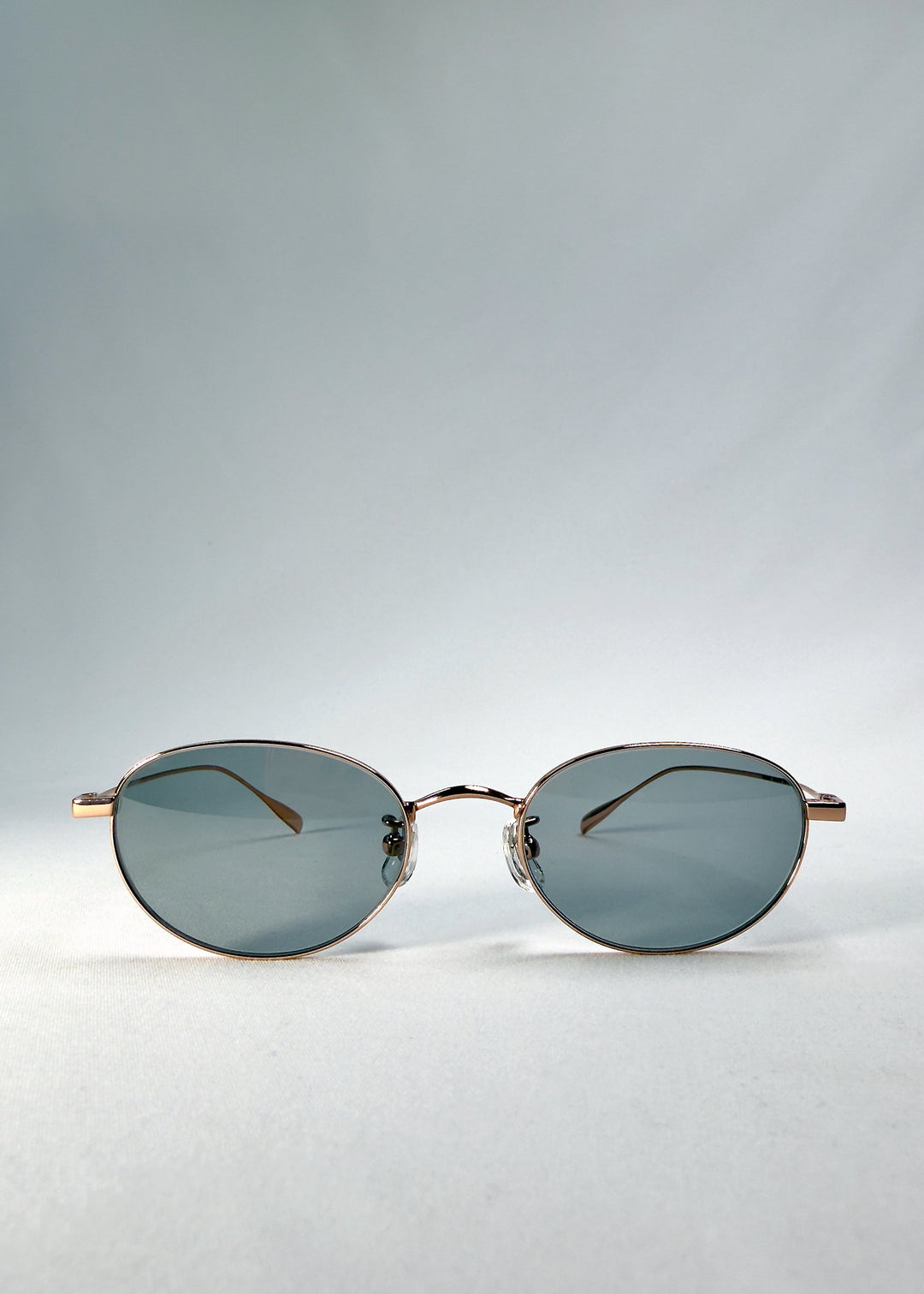 Front view of Vanta Arc Softint sunglasses in Sage Rose showing the rose-gold oval frame and smoke-green lenses. 