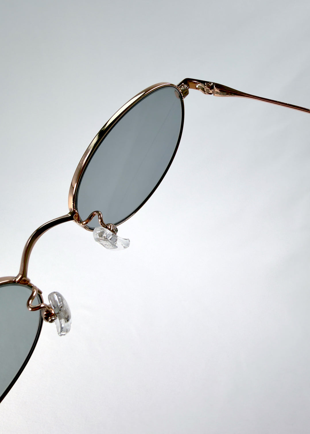 Close-up of Vanta Arc Softint sunglasses in Roselight highlighting lens edge and polished hinge detail.