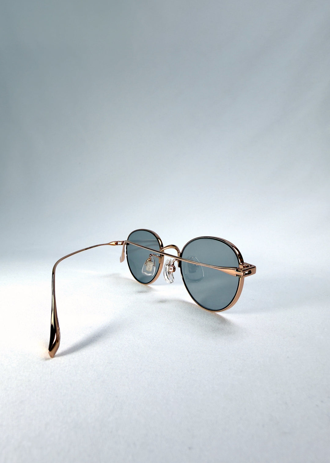 Left front-angle view of Vanta Arc Softint sunglasses in Sage Rose showing the slim frame and smoke-green lens tone. 