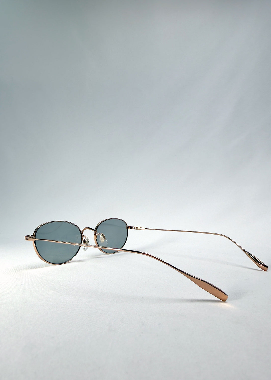Side-temple view of Vanta Arc Softint sunglasses in Sage Rose showing the rose-gold frame and titanium temples. 