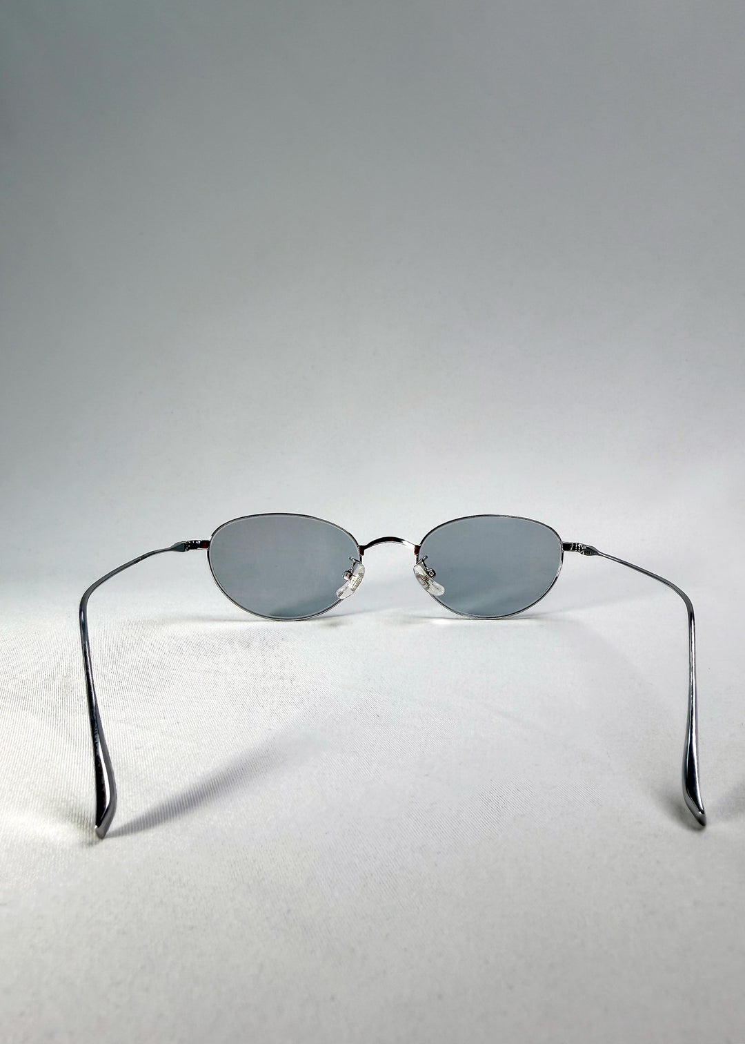 Back view of Vanta Arc Softint sunglasses in Silver Vein showing titanium temples and clean oval lines.
