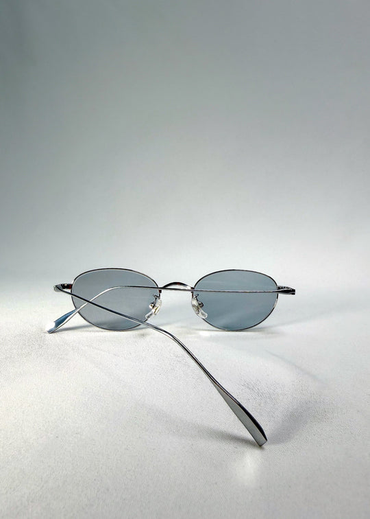 Folded-back view of Vanta Arc Softint sunglasses in Glacial Silver highlighting the minimalist silver finish. 