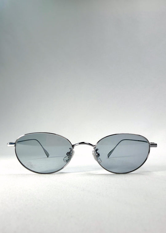 Front view of Vanta Arc Softint sunglasses in Glacial Silver showing the silver oval frame and grey-blue lenses. 