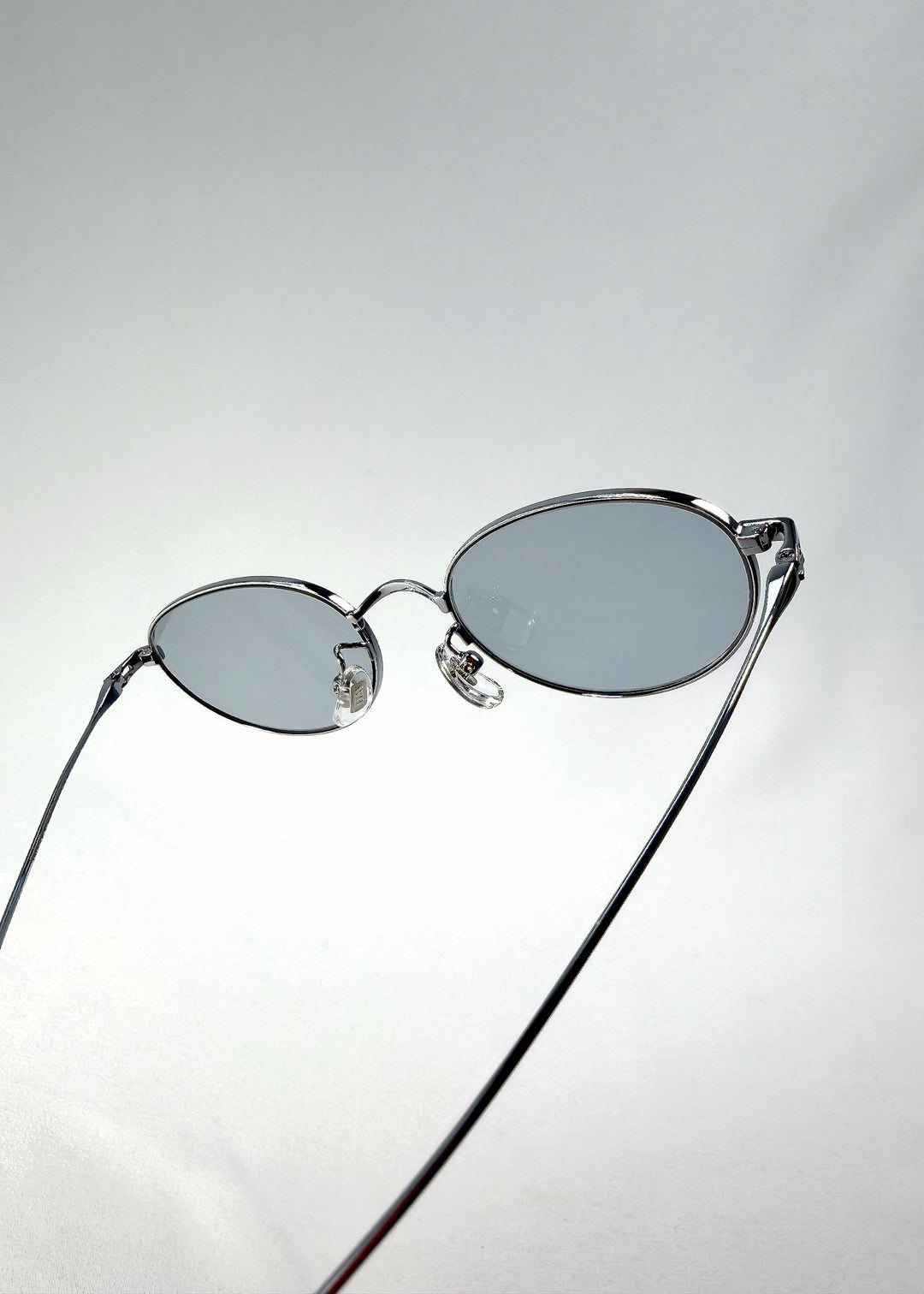Close-up of Vanta Arc Softint sunglasses in Silver Vein highlighting hinge and lens edge detail.