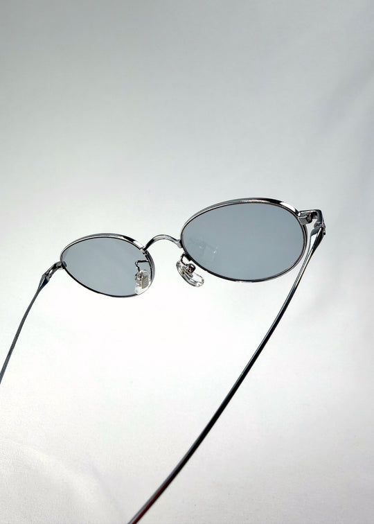 Close-up of Vanta Arc Softint sunglasses in Glacial Silver highlighting the hinge and grey-blue lens edge. 
