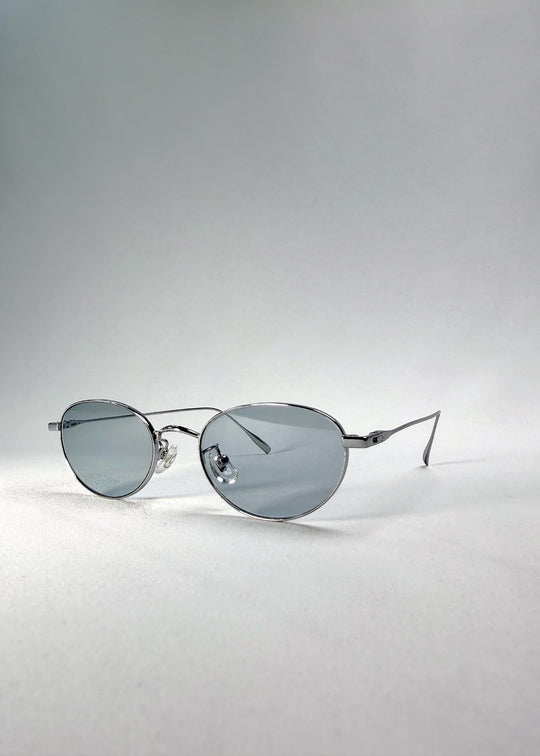 Left front-angle view of Vanta Arc Softint sunglasses in Glacial Silver showing the brushed-silver frame and cool grey-blue lenses. 