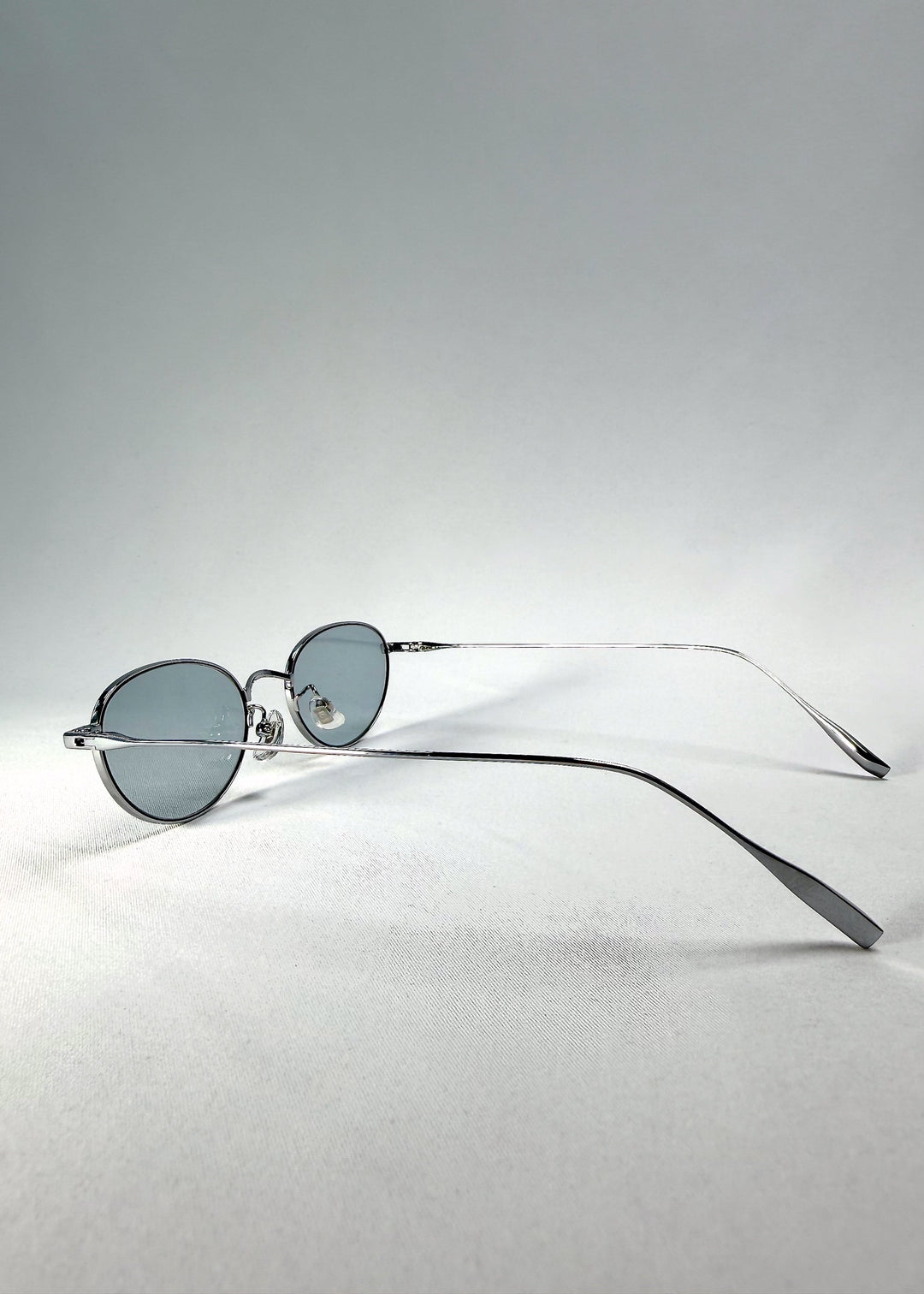 Side-temple view of Vanta Arc Softint sunglasses in Glacial Silver showing the slim silver titanium arms. 