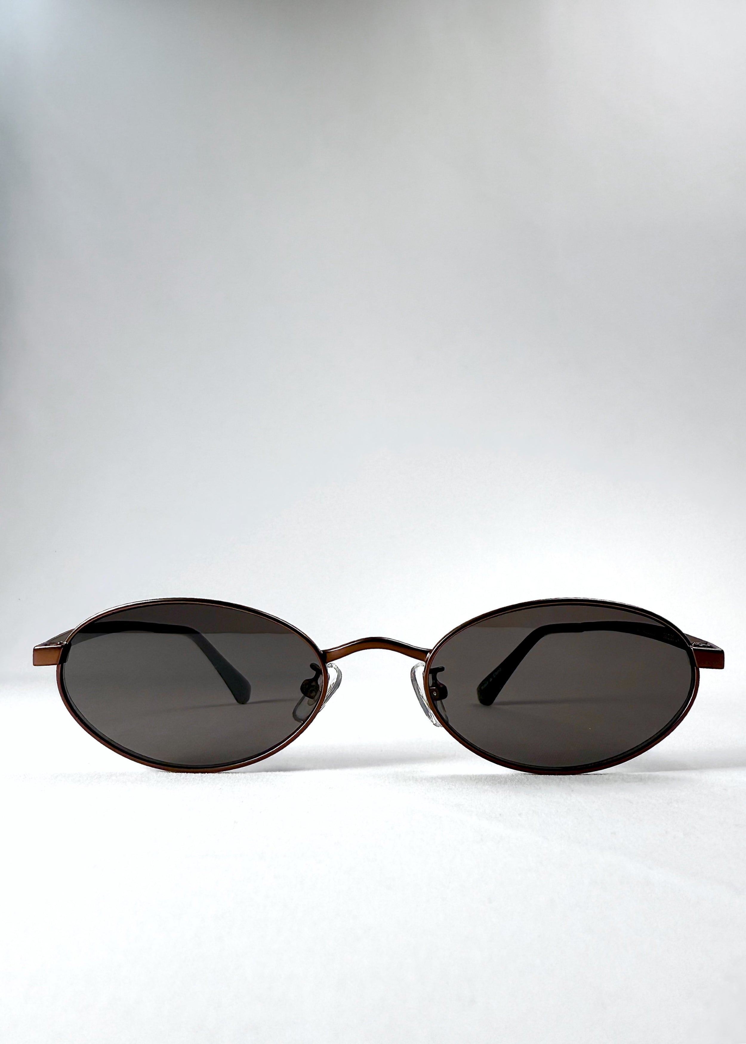Front view of Solstice – Espresso Bronze sunglasses showing the espresso-toned oval frame and smoky brown lenses.