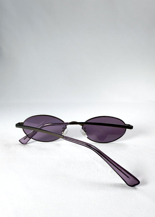 Solstice – Gunmetal Frost sunglasses viewed from the back in a folded position, showcasing the slim gunmetal frame and translucent purple temples. 