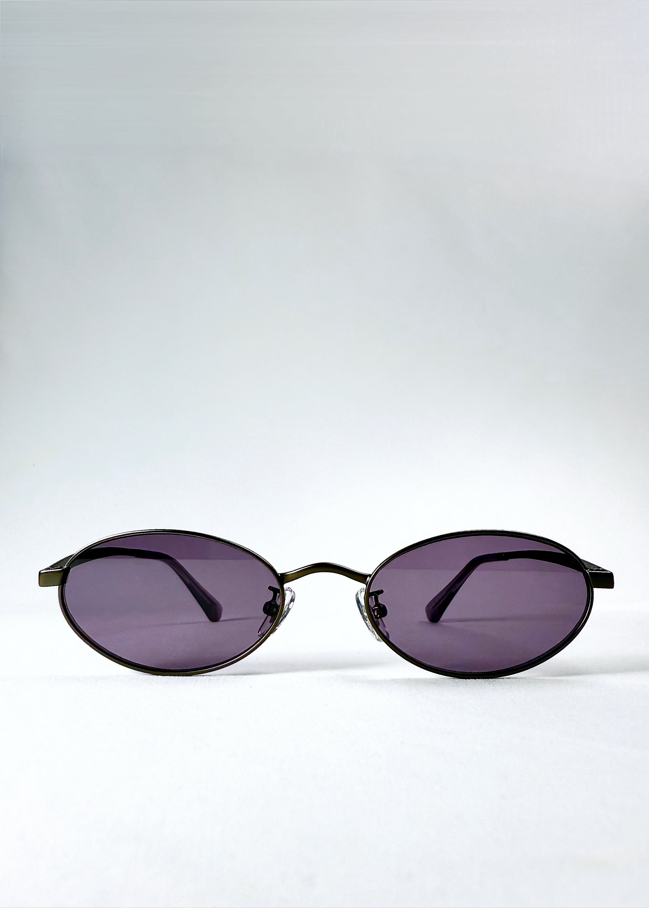 Front view of Solstice – Gunmetal Frost sunglasses showing the oval frame and purple lenses.