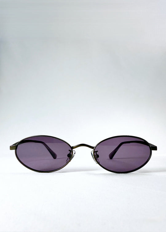 Front view of Solstice – Gunmetal Frost sunglasses showing the oval frame and purple lenses. 
