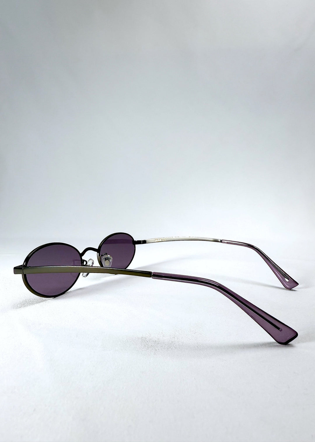 Side view of Solstice – Gunmetal Frost sunglasses highlighting the slim gunmetal arms and purple tips. 