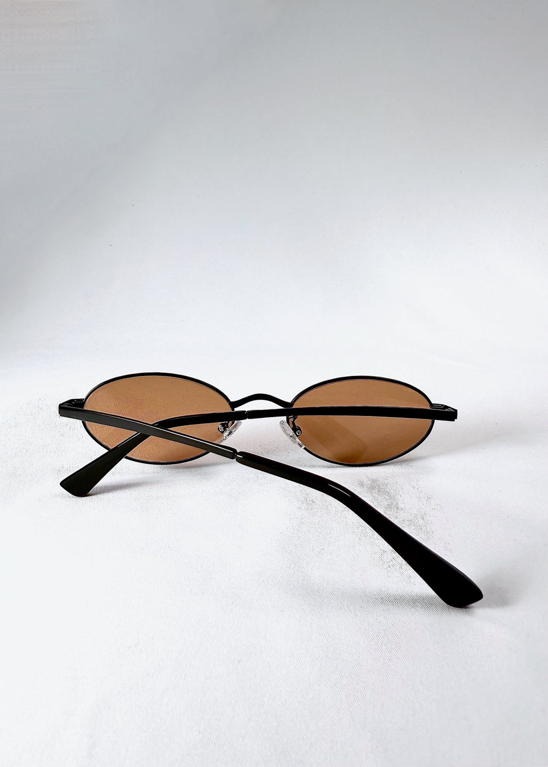 Folded back view of Solstice – Mahogany Black sunglasses showing the structure and smooth matte finish. 
