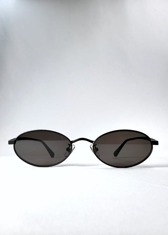 Front view of Solstice – Shadow Black sunglasses, showcasing the compact oval lenses and deep grey tint.