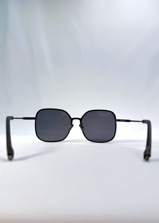 Back view of Spica sunglasses in Black, featuring light titanium frame and polarized lenses, showing the inside frame and open temples.