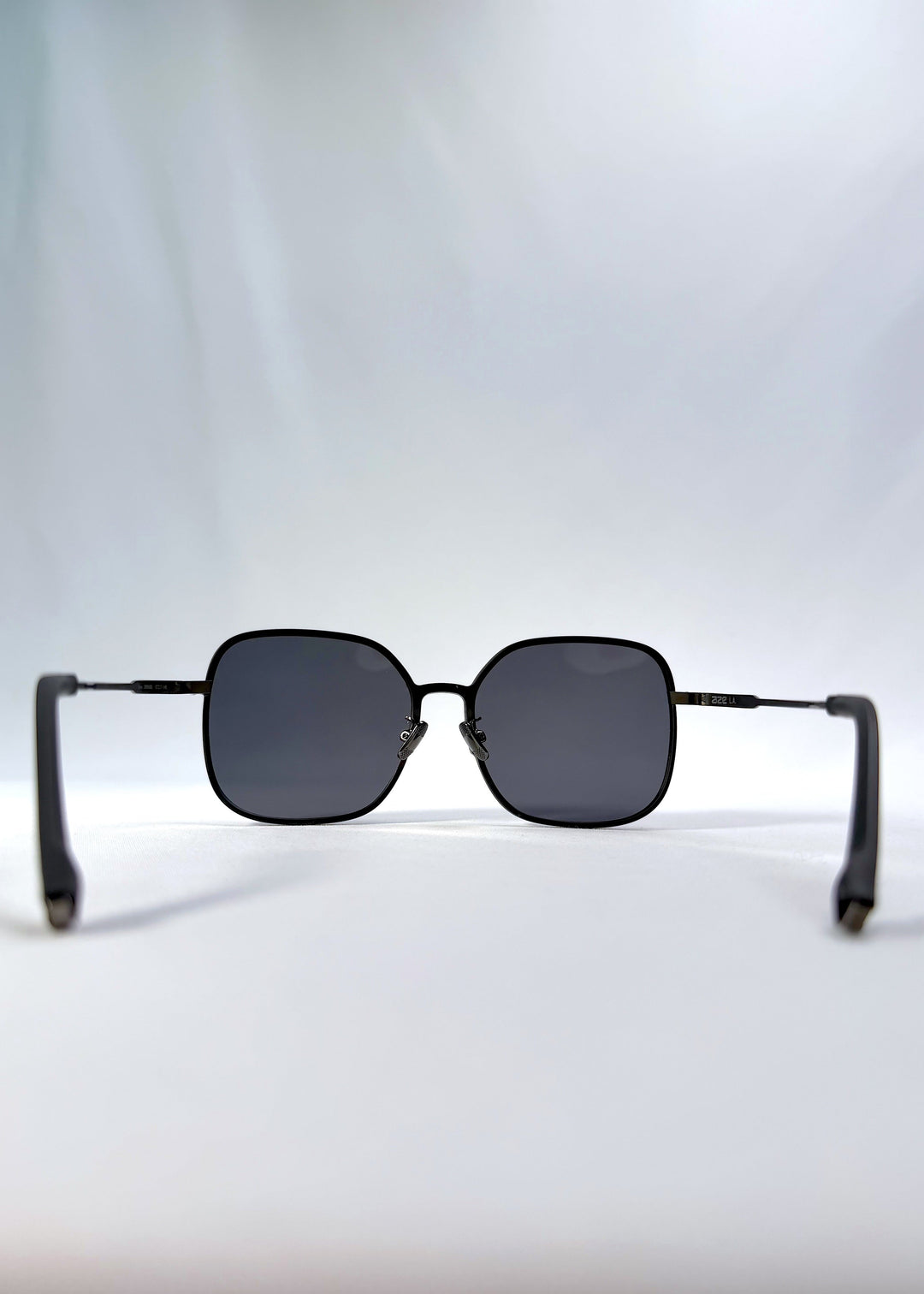 Back view of Spica sunglasses in Black, featuring an ultra-light frame with titanium temples and polarized lenses, showing the inside frame and open temples. 