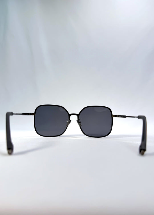Back view of Spica sunglasses in Black, featuring an ultra-light frame with titanium temples and polarized lenses, showing the inside frame and open temples. 