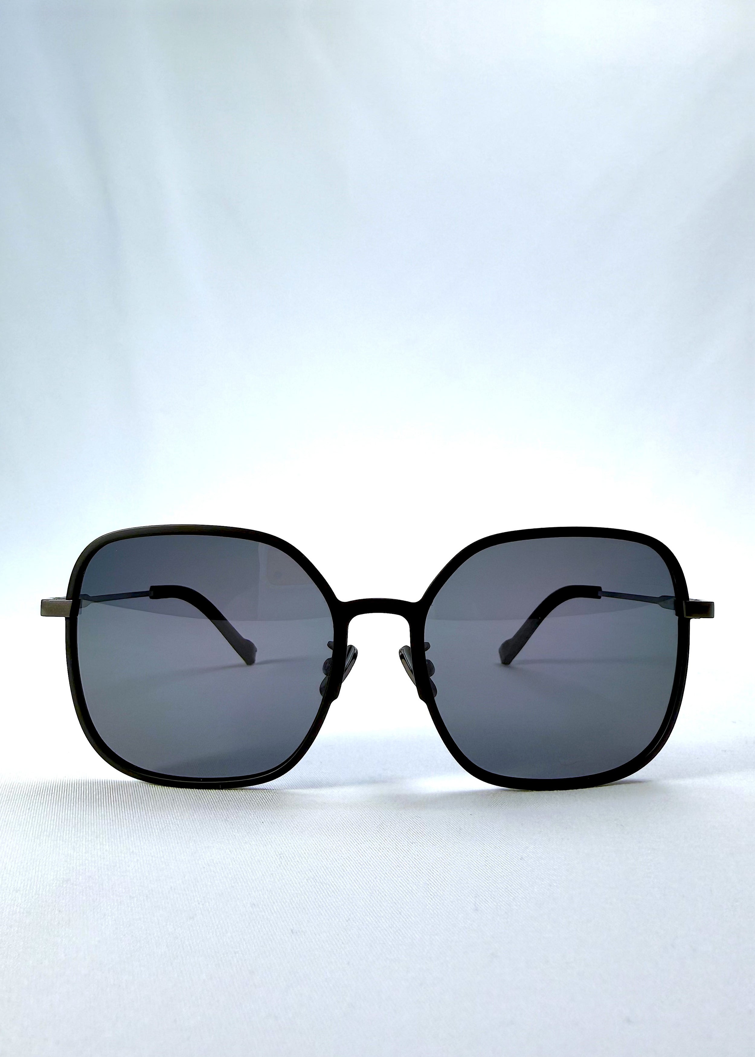 Front view of Spica sunglasses in Black, featuring light titanium frame and polarized lenses, showing the full front silhouette.