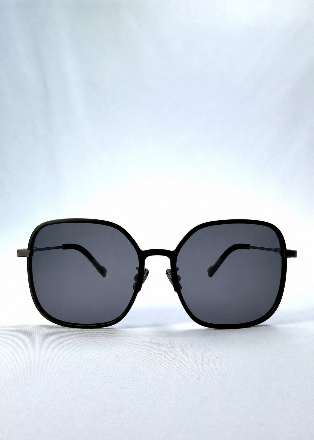 Front view of Spica sunglasses in Black, featuring light titanium frame and polarized lenses, showing the full front silhouette.