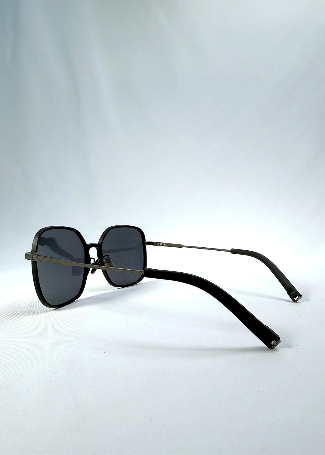 Side-angle view of Spica sunglasses in Black, featuring an ultra-light frame with titanium temples and polarized lenses, showing the lens shape and temple profile. 