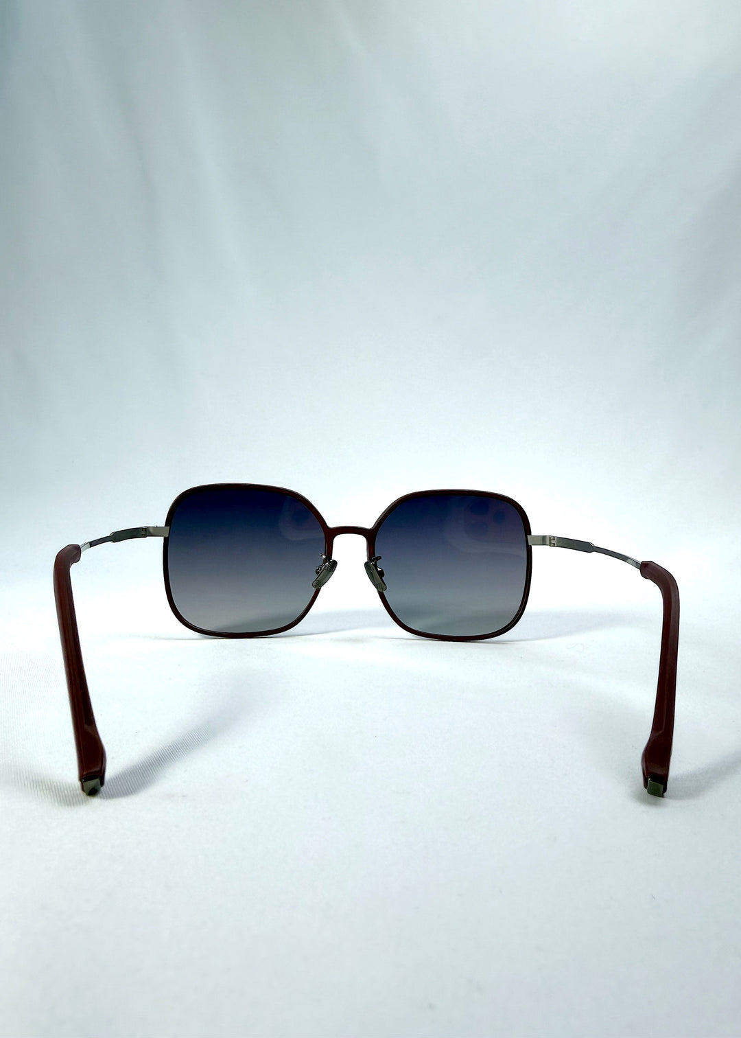 Back view of Spica sunglasses in Cherry Red, featuring light titanium frame and polarized lenses, showing the inside frame and open temples.