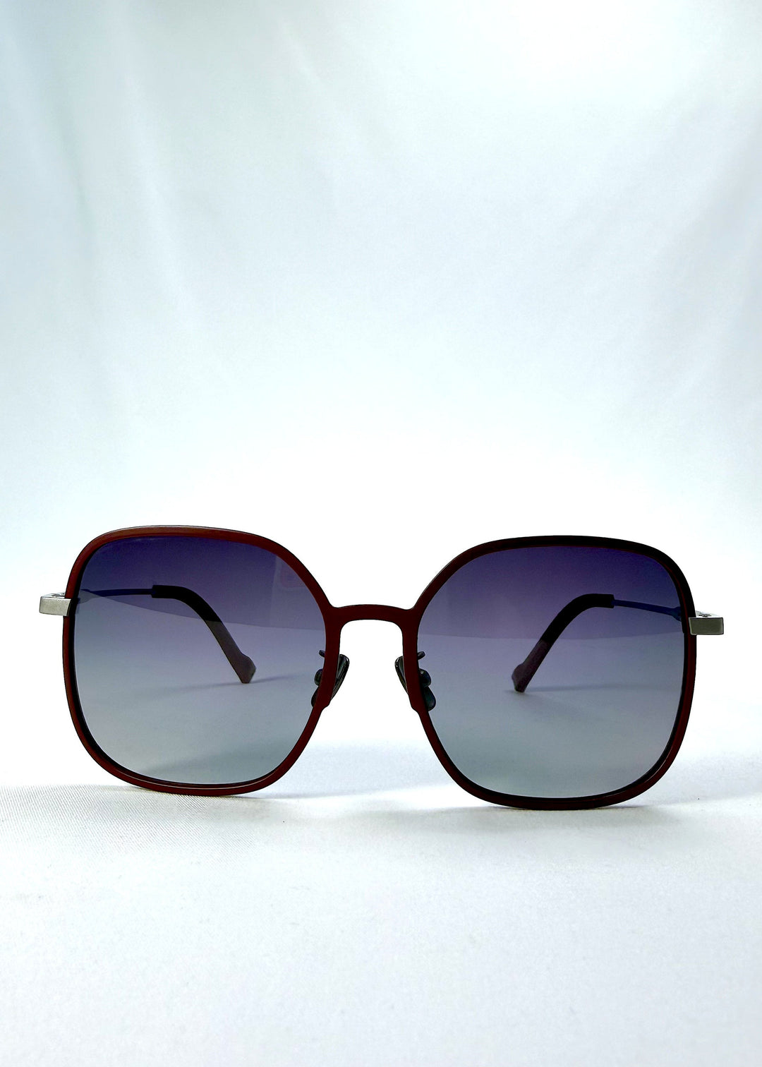 Front view of Spica sunglasses in Cherry Red, featuring an ultra-light frame with titanium temples and polarized lenses, showing the full front silhouette. 