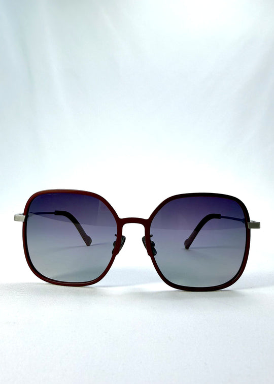 Front view of Spica sunglasses in Cherry Red, featuring an ultra-light frame with titanium temples and polarized lenses, showing the full front silhouette. 