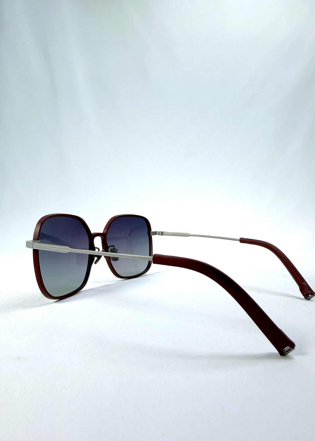 Side-angle view of Spica sunglasses in Cherry Red, featuring an ultra-light frame with titanium temples and polarized lenses, showing the lens shape and temple profile. 