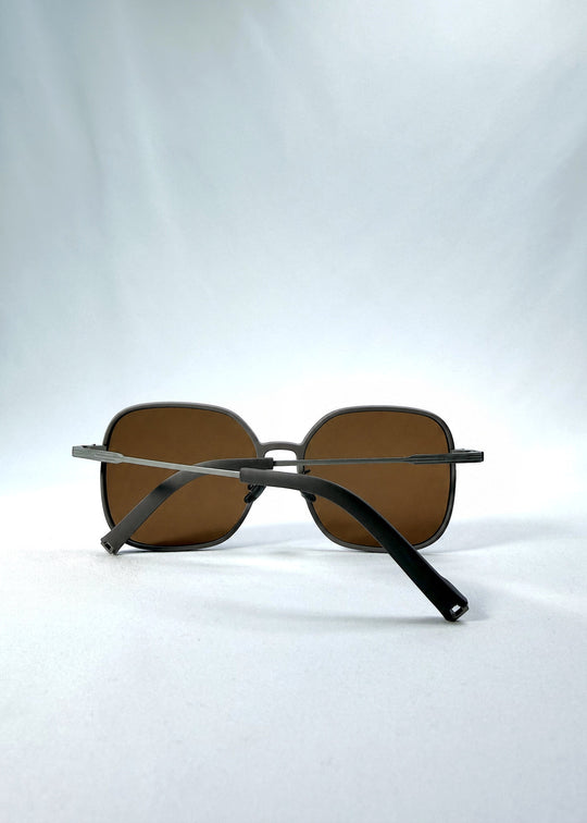 Folded view of Spica sunglasses in Milk Tea Brown, featuring an ultra-light frame with titanium temples and polarized lenses, showing the folded temples and frame profile. 
