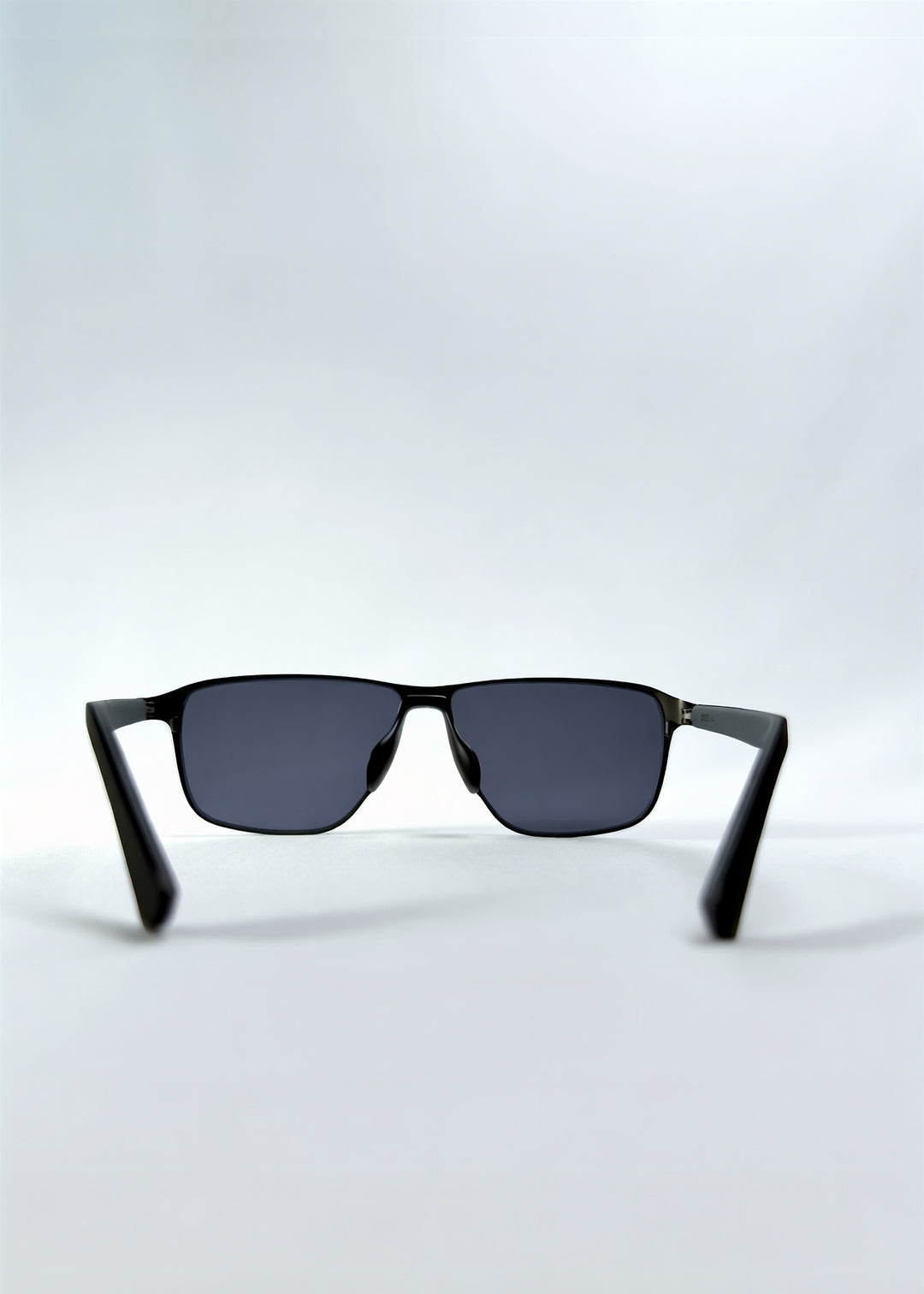 Back view of Vector Line sunglasses in Matte Black, featuring wide matte black rectangular metal frame and full grey polarized lenses, showing the inside frame and open temples.