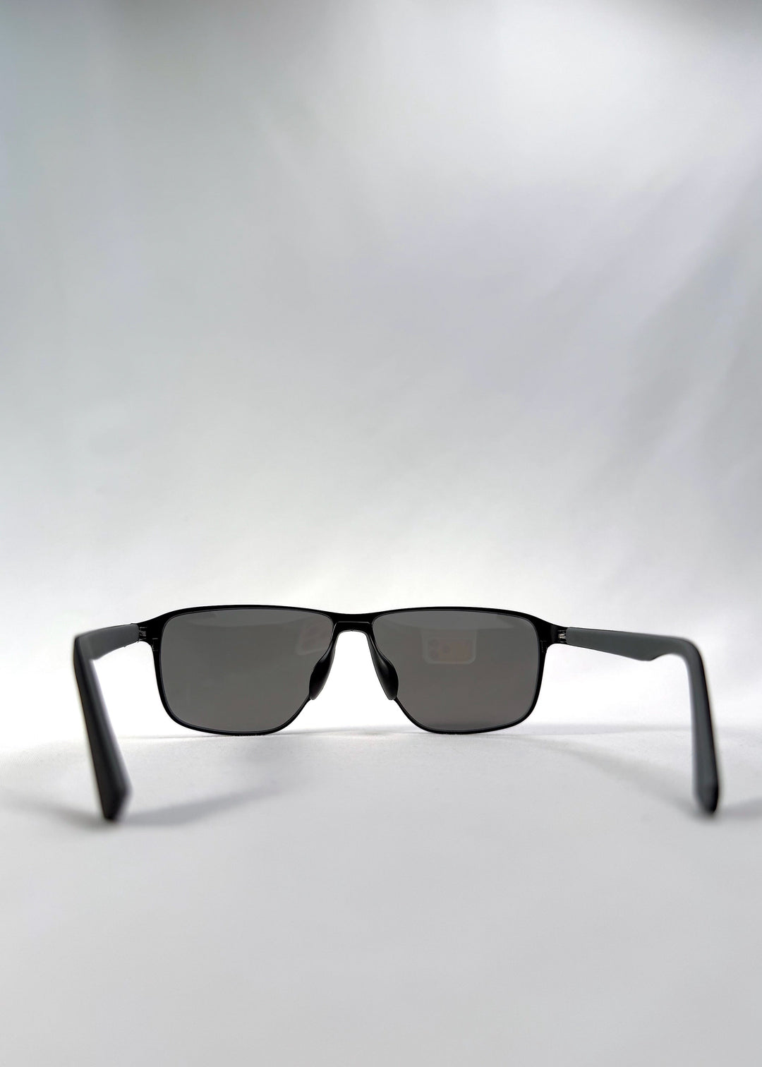 Back view of Vector Line sunglasses in Mercury Shadow, featuring wide black metal frame and silver mirrored polarized lenses, showing the inside frame and open temples. 